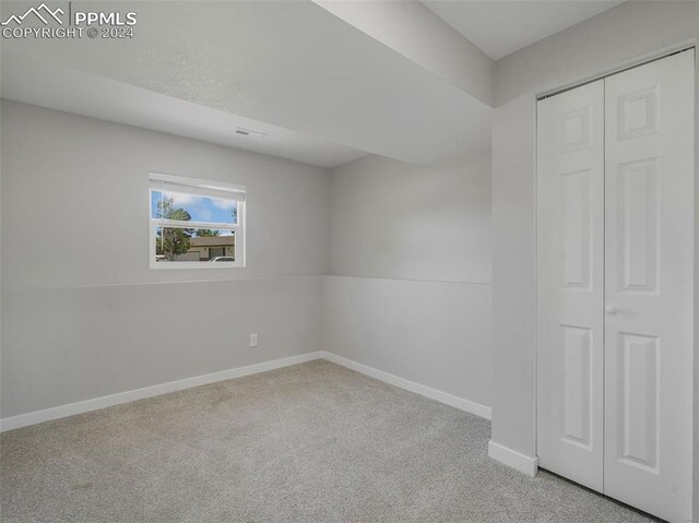 unfurnished bedroom featuring carpet and a closet