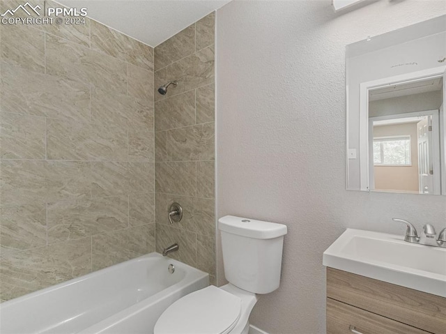 full bathroom featuring tiled shower / bath combo, toilet, and vanity