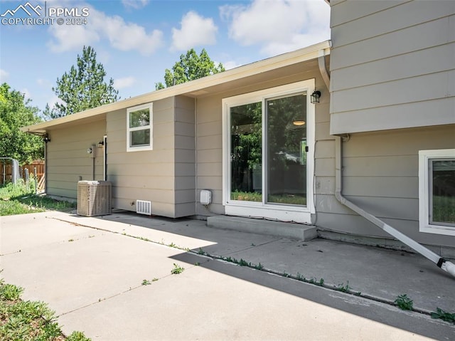 rear view of house featuring central air condition unit and a patio