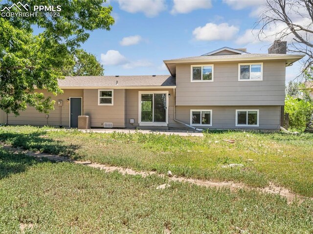 rear view of property featuring a patio, a yard, and central air condition unit