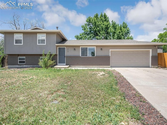 tri-level home featuring a garage and a front lawn