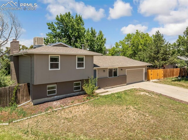 tri-level home featuring a front lawn and a garage