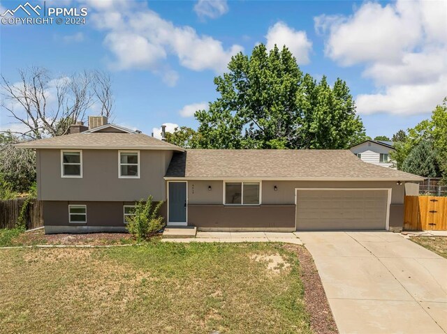 tri-level home with a front lawn and a garage