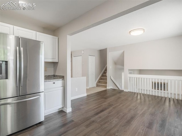 kitchen featuring white cabinetry, light stone countertops, dark wood-type flooring, and stainless steel refrigerator with ice dispenser