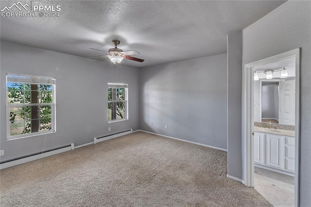 unfurnished bedroom featuring light carpet, a baseboard radiator, ensuite bath, and ceiling fan