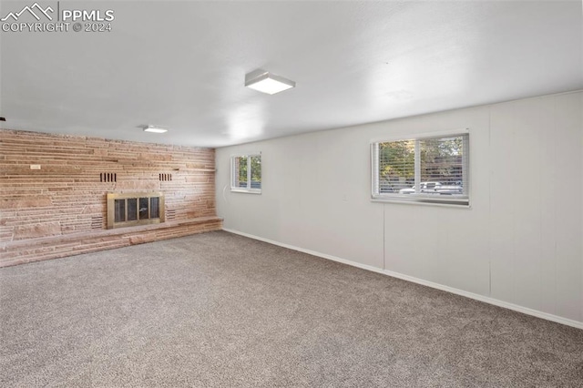 basement with a brick fireplace and carpet flooring