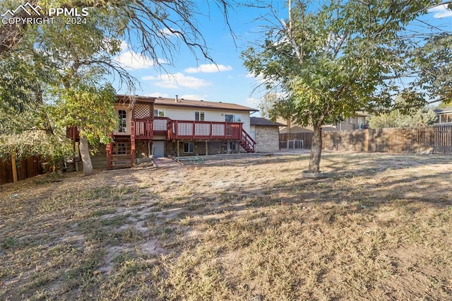 back of property with a lawn and a deck