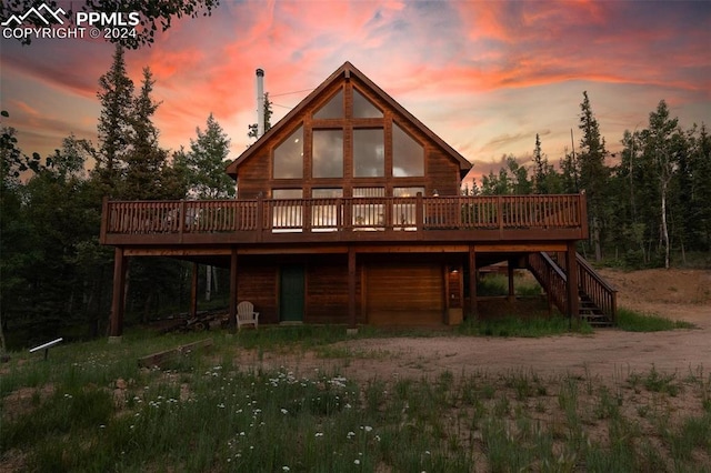 back house at dusk featuring a wooden deck