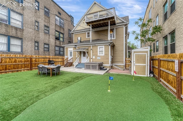 rear view of house with a storage shed and a patio