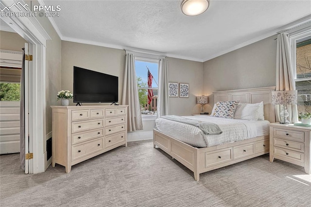 bedroom with light carpet, a textured ceiling, and ornamental molding