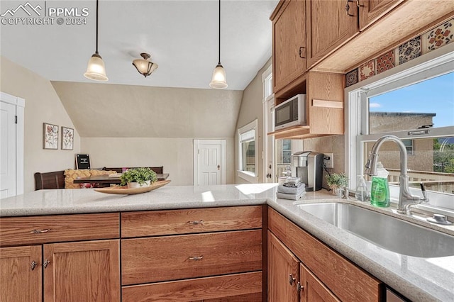 kitchen with pendant lighting, lofted ceiling, sink, and built in microwave