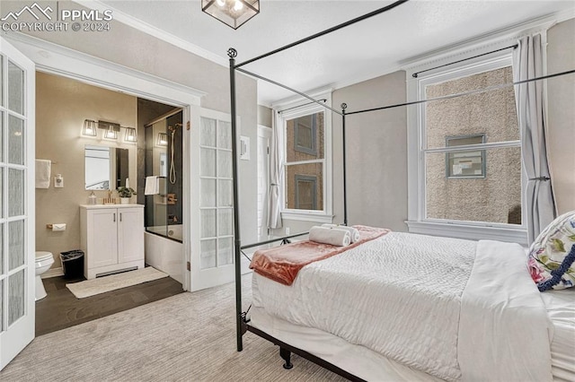 bedroom with wood-type flooring, connected bathroom, french doors, and crown molding