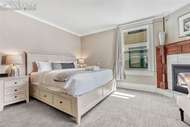 carpeted bedroom with a fireplace and ornamental molding