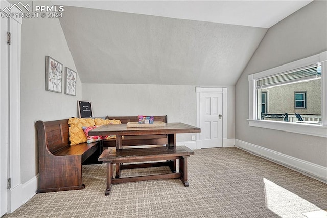 dining space featuring carpet and lofted ceiling