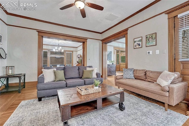 living room featuring ceiling fan with notable chandelier and ornamental molding