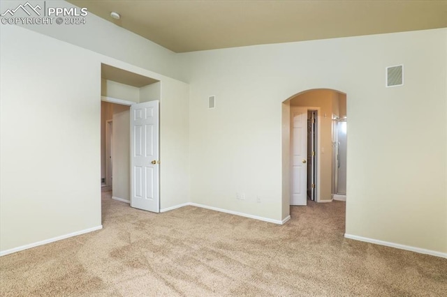 unfurnished room featuring light colored carpet