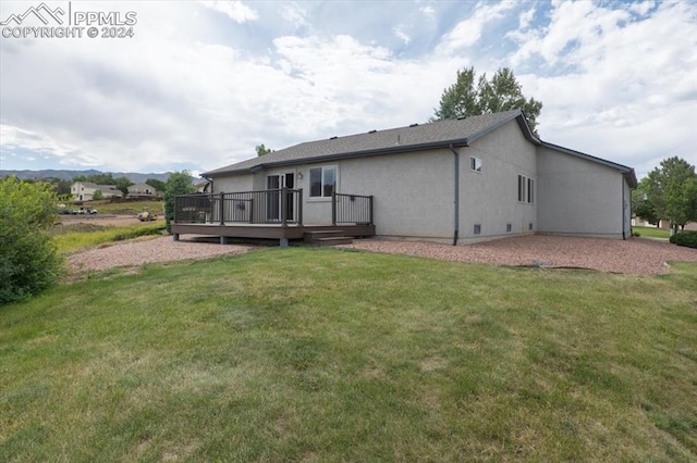 back of house with a yard and a wooden deck