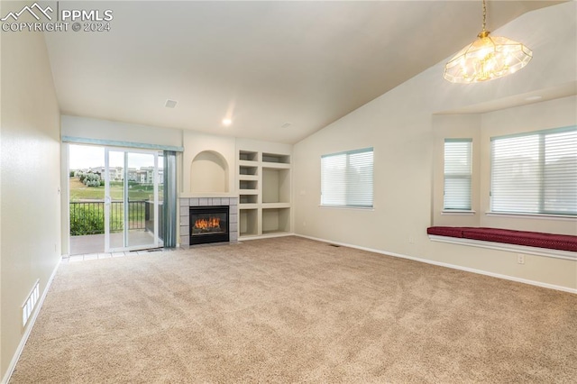 unfurnished living room featuring carpet flooring, built in shelves, a fireplace, and lofted ceiling