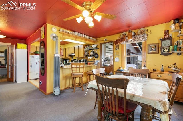 carpeted dining area featuring ceiling fan