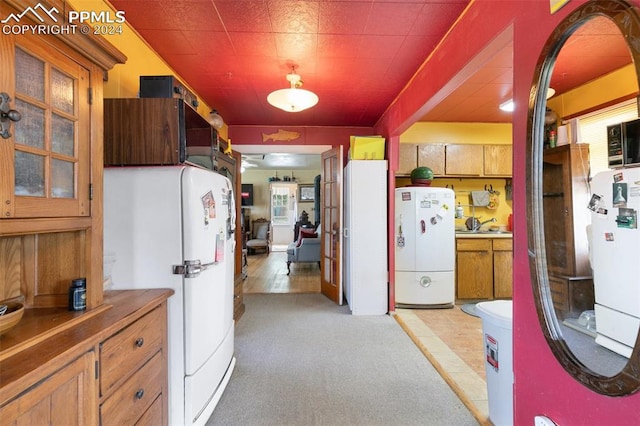 kitchen with light tile patterned flooring and white fridge