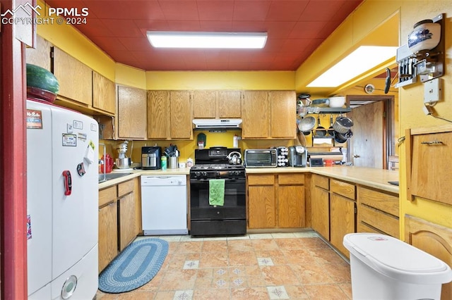 kitchen featuring light tile patterned flooring and white appliances