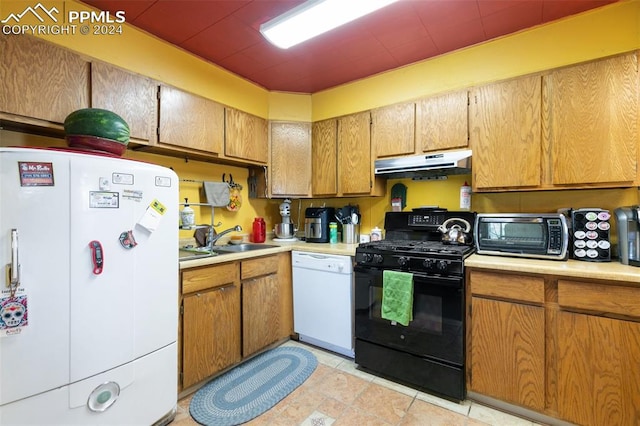 kitchen with light tile patterned floors, white appliances, and sink