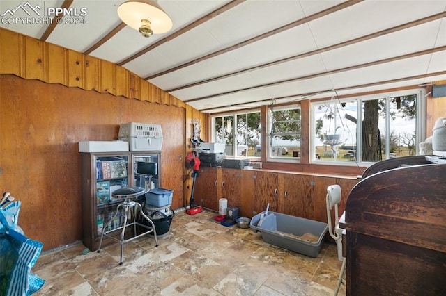 misc room featuring wooden walls, tile patterned flooring, and vaulted ceiling with beams