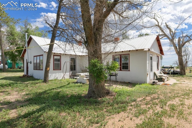 back of property featuring a yard