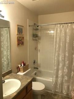 full bathroom with toilet, vanity, and shower / bath combo