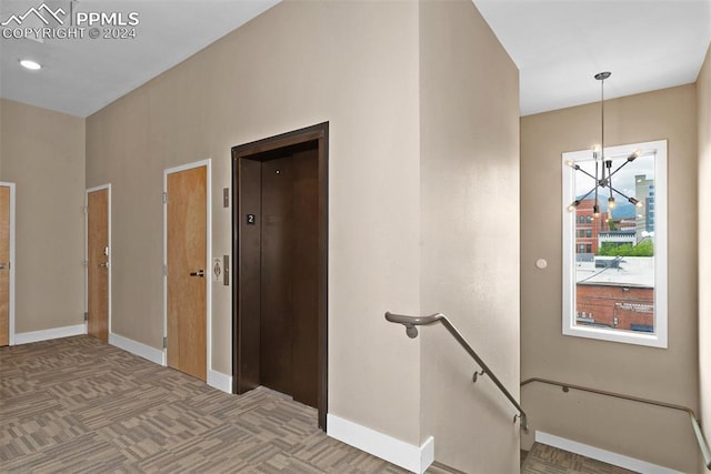 interior space featuring elevator and an inviting chandelier