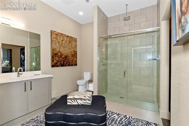 bathroom featuring tile patterned floors, a shower with door, vanity, and toilet