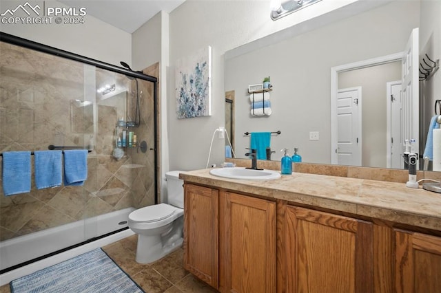 bathroom featuring vanity, toilet, an enclosed shower, and tile patterned floors