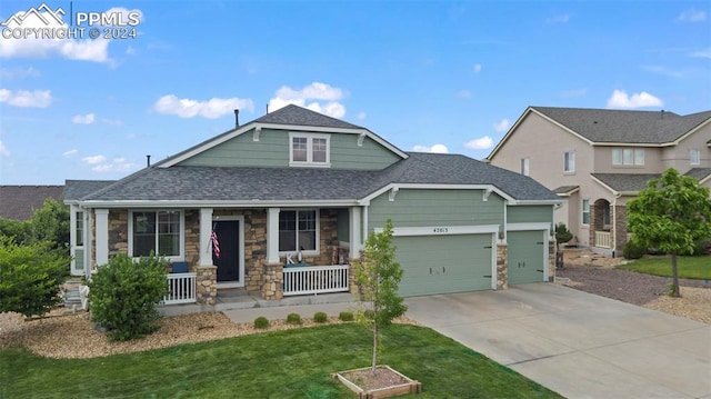 craftsman-style house featuring a garage, a porch, and a front lawn