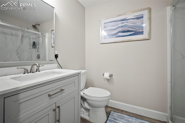 bathroom featuring vanity, toilet, hardwood / wood-style flooring, and an enclosed shower