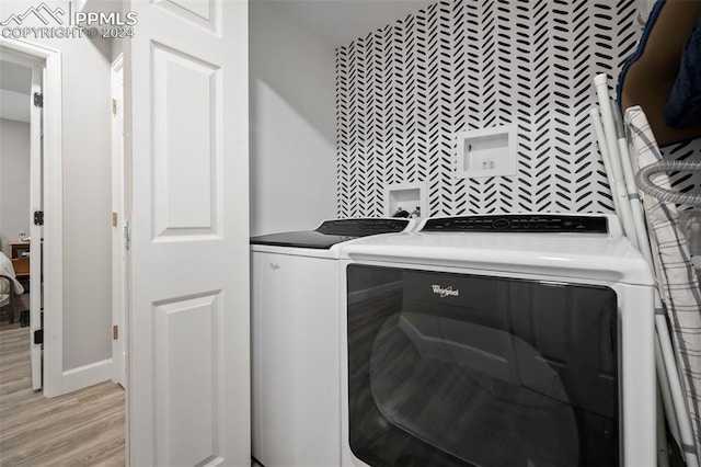 laundry room featuring light hardwood / wood-style floors and washing machine and clothes dryer