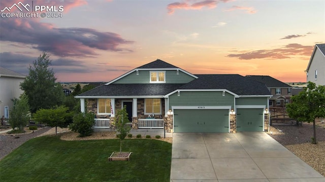 craftsman-style house featuring a garage, a porch, and a lawn