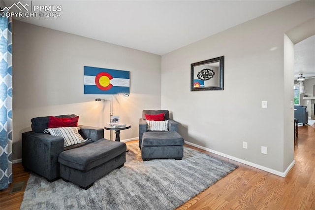 sitting room featuring wood-type flooring and ceiling fan