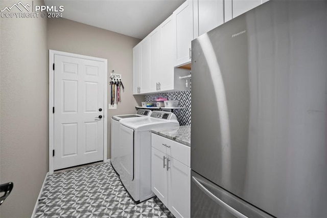 laundry area with washing machine and clothes dryer and cabinets