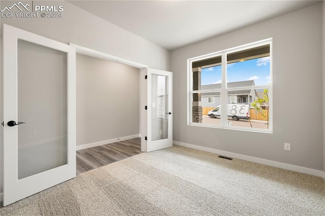 unfurnished bedroom with wood-type flooring and french doors