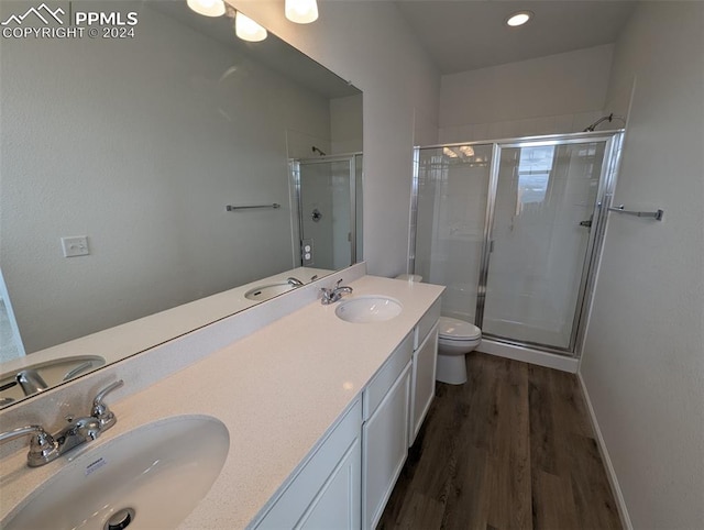 bathroom featuring vanity, hardwood / wood-style flooring, toilet, and an enclosed shower