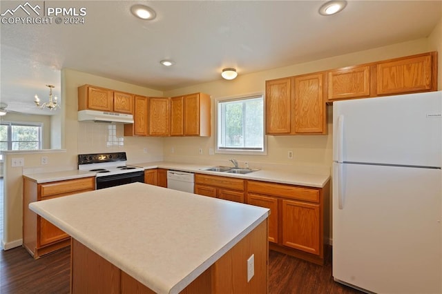 kitchen with a center island, a healthy amount of sunlight, white appliances, and sink