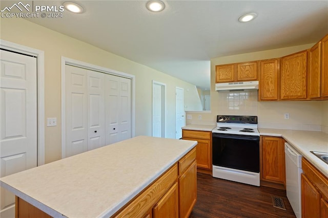 kitchen featuring white appliances, a center island, dark hardwood / wood-style floors, and backsplash