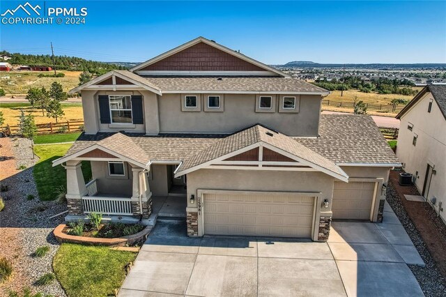 craftsman-style house with covered porch, a garage, and central air condition unit