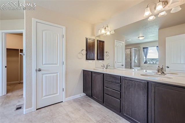 bathroom featuring tile patterned flooring, an enclosed shower, vanity, and an inviting chandelier