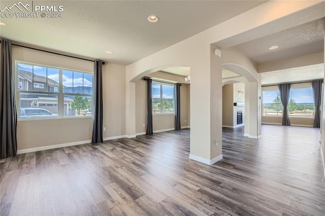 spare room with a textured ceiling and hardwood / wood-style flooring