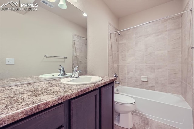 full bathroom featuring tile patterned floors, tiled shower / bath combo, vanity, and toilet