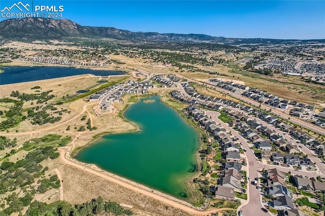 birds eye view of property with a water and mountain view