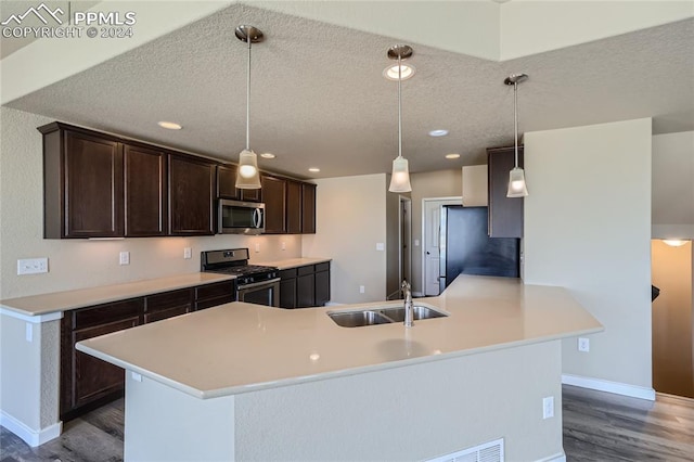 kitchen with decorative light fixtures, sink, appliances with stainless steel finishes, and dark wood-type flooring