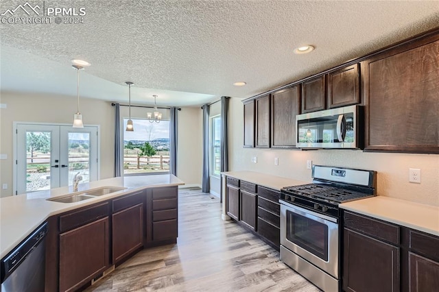 kitchen with a notable chandelier, sink, dark brown cabinetry, hanging light fixtures, and stainless steel appliances