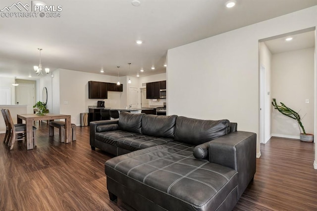 living room with a chandelier and dark wood-type flooring